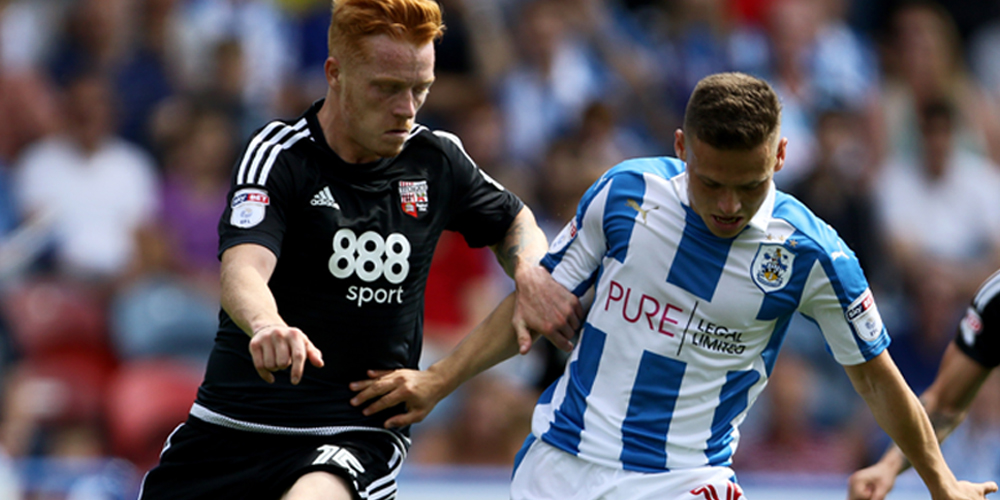 Huddersfield Town's Jack Payne (right) and Brentford's Ryan Woods challenge for the ball during the Sky Bet Championship match at the John Smith's Stadium, Huddersfield.