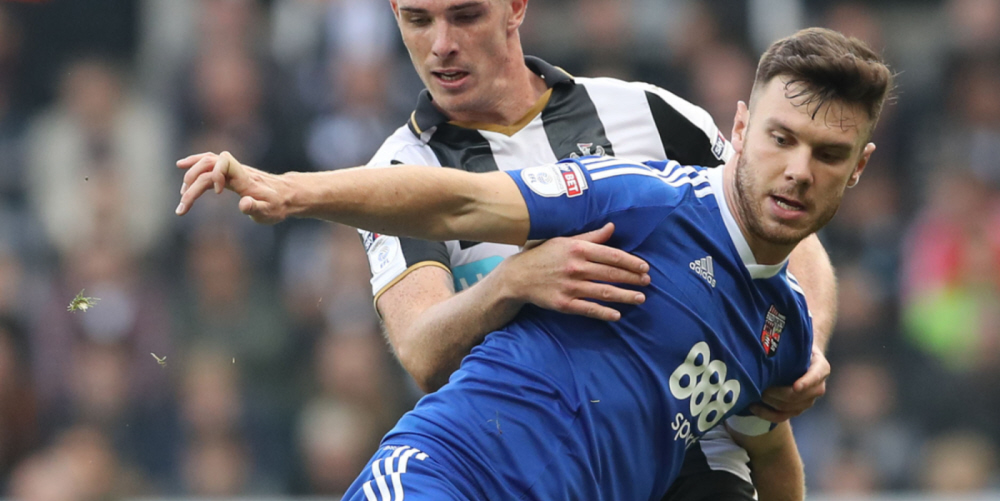 Newcastle United's Ciaran Clark (left) and Brentford's Scott Hogan battle for the ball during the Sky Bet Championship match at St James' Park, Newcastle.