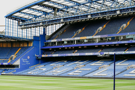 A wide view of the empty blue stands and roof structure at Chelsea
